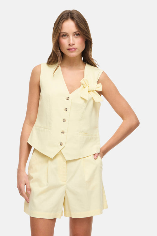 Blazer jaune de VILA, avec boutons sur le devant et un nœud décoratif sur l'épaule.