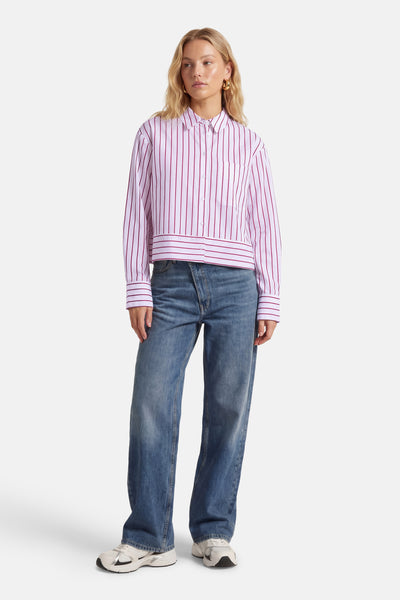 Chemise à manches longues rayée rouge et blanc de VILA®, portée avec un jean bleu ample et des baskets blanches.