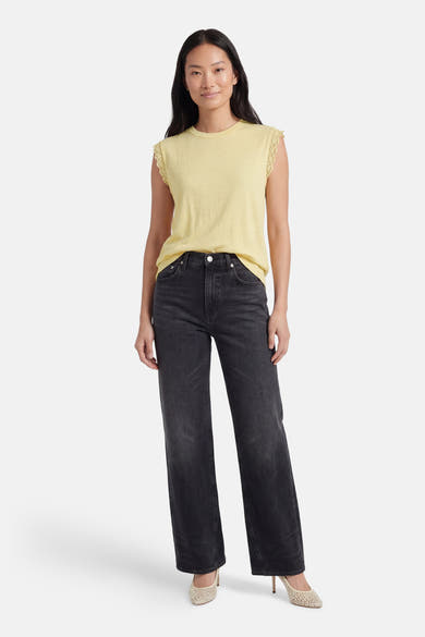 Top sans manches jaune de VILA® avec bordure en dentelle, porté avec un jean noir et des talons.