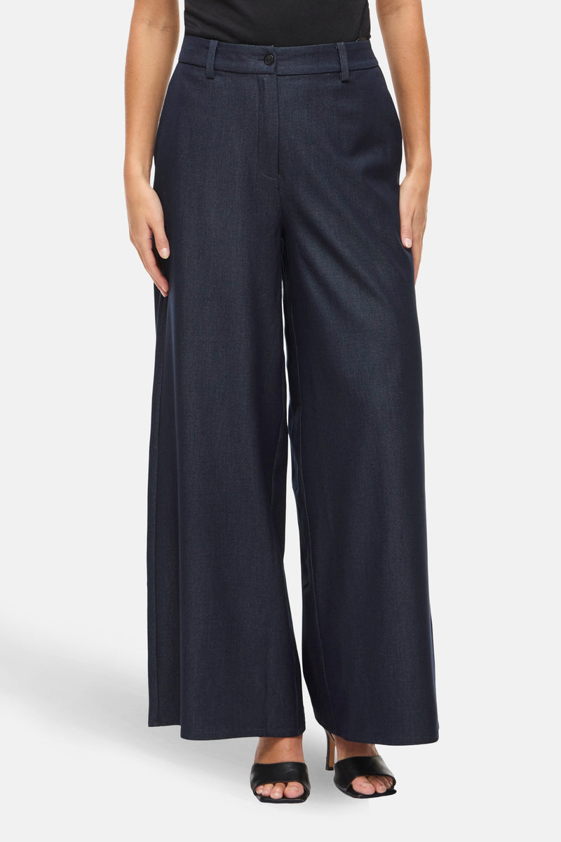 Pantalon large bleu de VILA®, avec une coupe fluide et des chaussures noires à talons hauts.