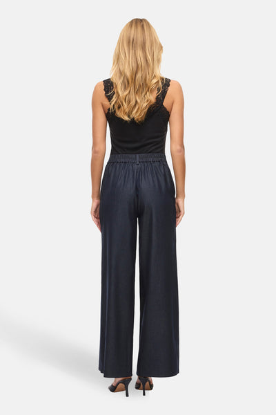 Pantalon bleu par VILA®, ample et fluide, porté avec un haut noir à dentelle.