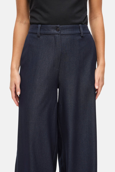 Pantalon bleu de VILA®, coupe ample et taille haute, porté avec un haut noir.