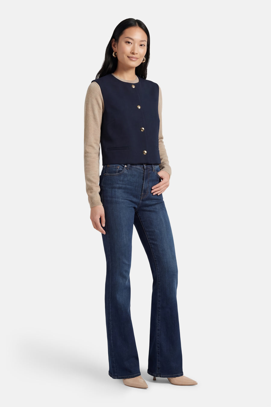 Blazer bleu VILA®, porté avec un pull beige à manches longues et un jean évasé.
