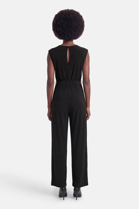 Zwarte VILA jumpsuit van achteren gezien, met sleutelgatuitsparing, strikceintuur en wijde pijpen.