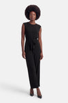 Combinaison noire sans manches à col rond de VILA avec taille à nouer et jambes larges, portée avec des escarpins noirs.