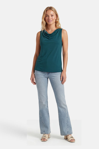 Top vert sans manches de VILA® avec col bénitier, porté par un mannequin avec un jean et des mules beiges.