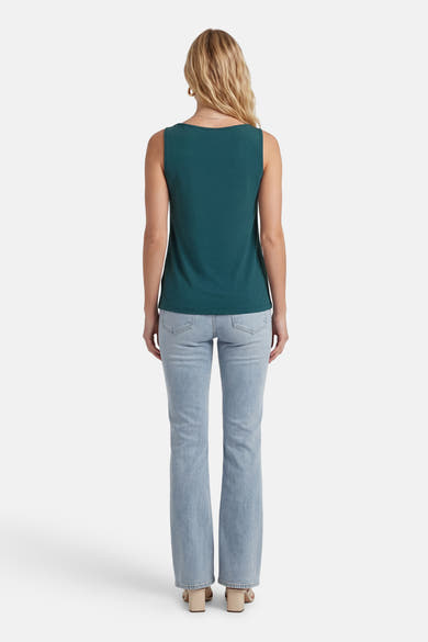 Top sans manches vert de VILA, vu de dos, porté avec un jean délavé et des sandales à talons bloc beige.