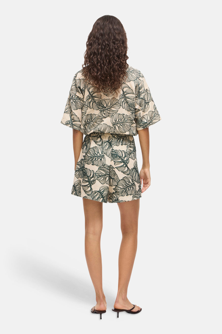 Short multicolore de VILA avec motif feuilles vertes et taille élastique, porté de dos.