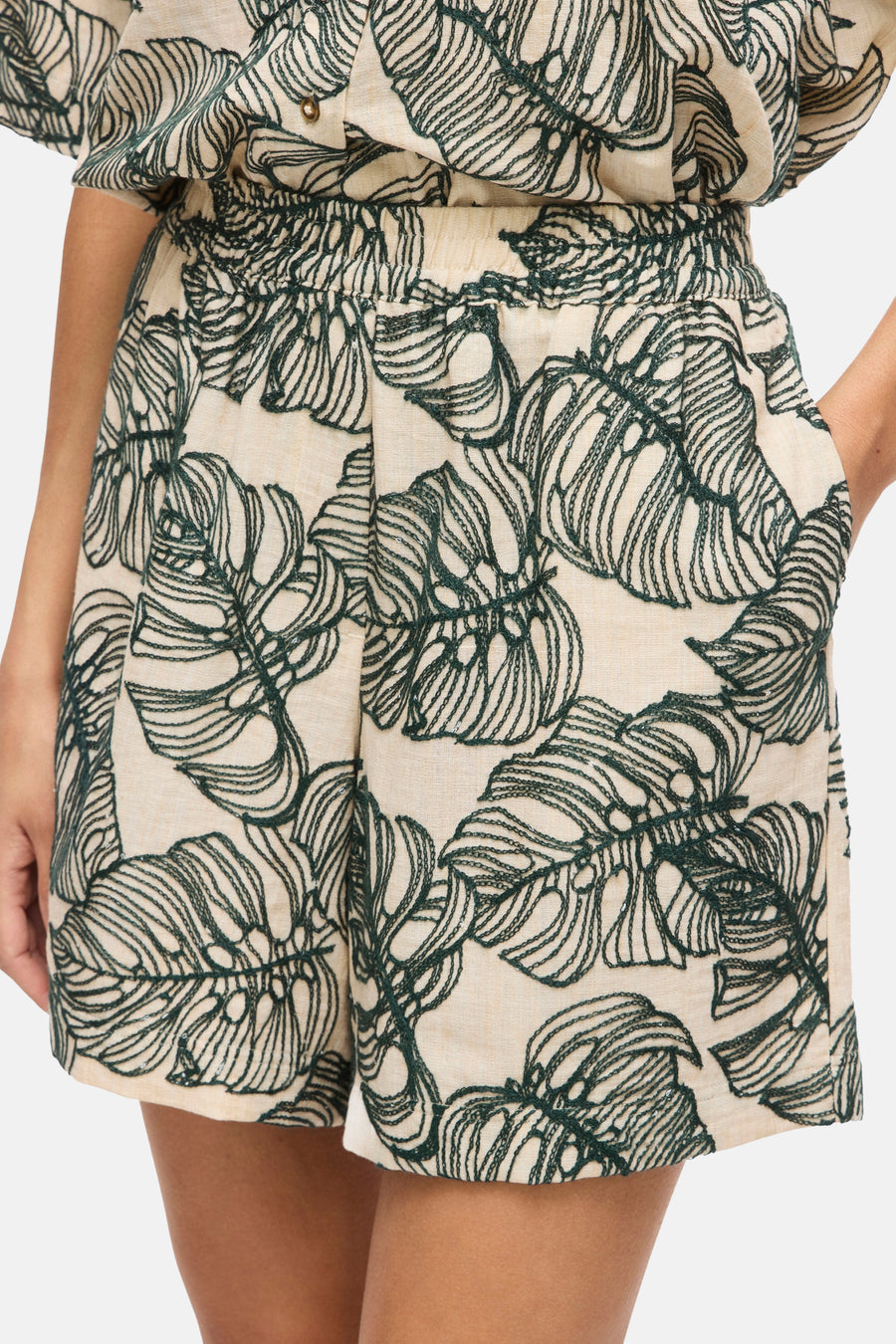 Short beige et vert foncé de VILA, avec broderie de feuilles tropicales et taille élastiquée.