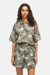 Beige korte mouwen blouse met groen bladpatroon van VILA®, gedragen met een bijpassende short en muiltjes met hak.