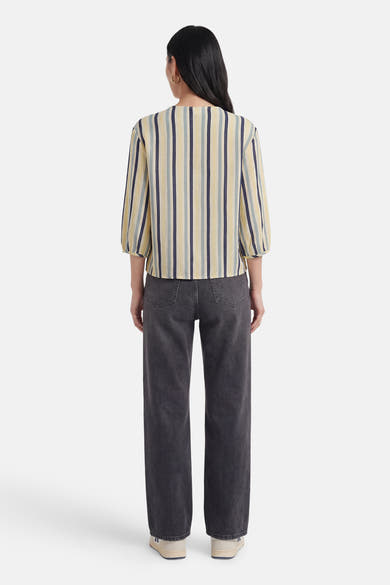 Chemise multicolore de VILA® à rayures verticales jaunes, bleues et grises, manches 3/4 bouffantes, portée de dos avec un jean gris foncé.