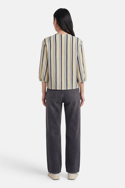 Chemise multicolore de VILA® à rayures verticales jaunes, bleues et grises, manches 3/4 bouffantes, portée de dos avec un jean gris foncé.