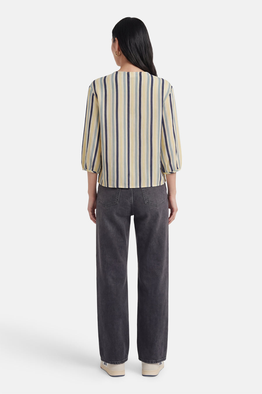 Chemise multicolore de VILA® à rayures verticales jaunes, bleues et grises, manches 3/4 bouffantes, portée de dos avec un jean gris foncé.