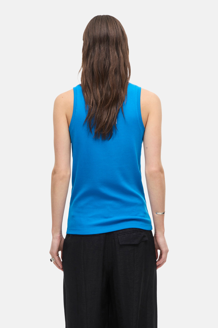 Top sans manches bleu de ROUGE EDIT, porté avec un pantalon noir ample, vue de dos.