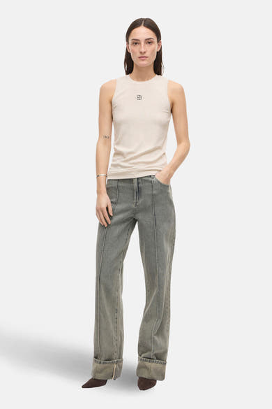 Top sans manches beige par ROUGE EDIT, porté avec un jean gris taille haute et des chaussures marron.
