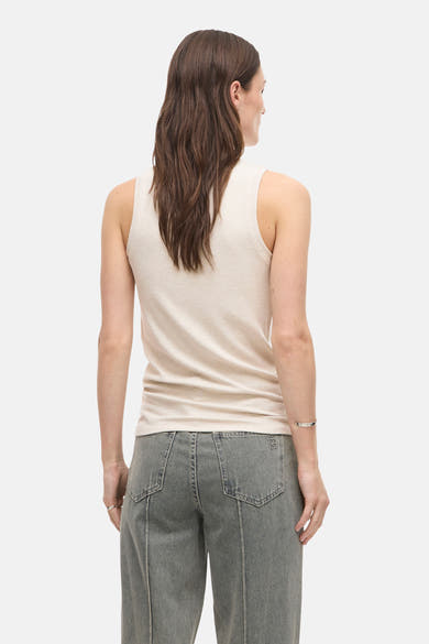Top sans manches beige de ROUGE EDIT, texture côtelée, porté avec un pantalon gris taille haute, vue de dos.