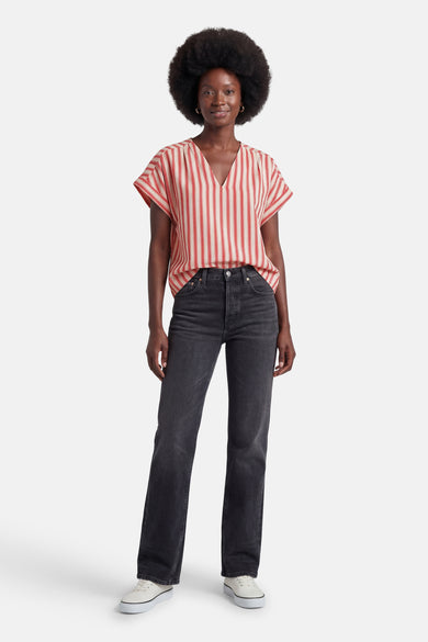 Gestreept bloesje met rode en crèmekleurige verticale strepen van VILA®, V-hals en korte mouwen, gedragen met een zwarte jeans en witte sneakers.