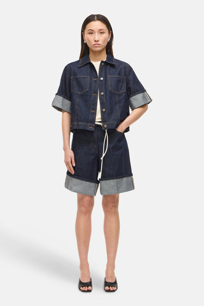 Chemise bleu foncé en denim de ROUGE EDIT, portée avec un short assorti à cordon et des chaussures ouvertes noires.
