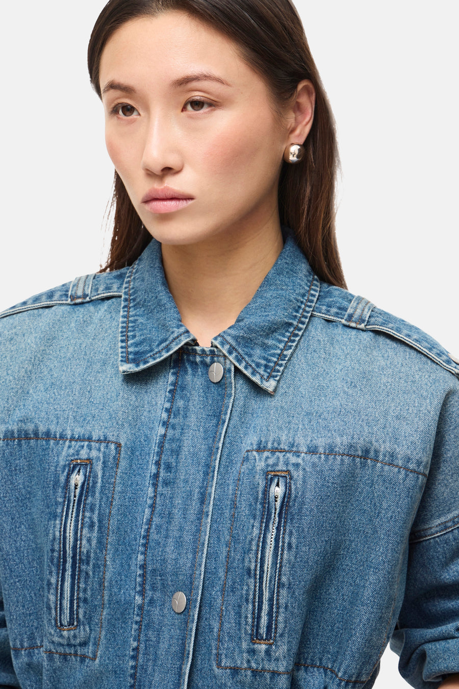 Veste courte en denim bleu moyen de ROUGE EDIT, avec col, boutons argentés et poches zippées.