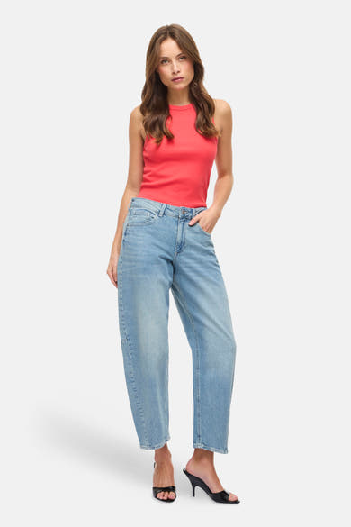 Jeans en denim bleu clair de VILA, portés avec un haut rouge et des chaussures à talons noires.
