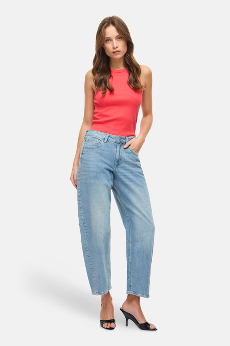 Jeans en denim bleu clair de VILA, portés avec un haut rouge et des chaussures à talons noires.
