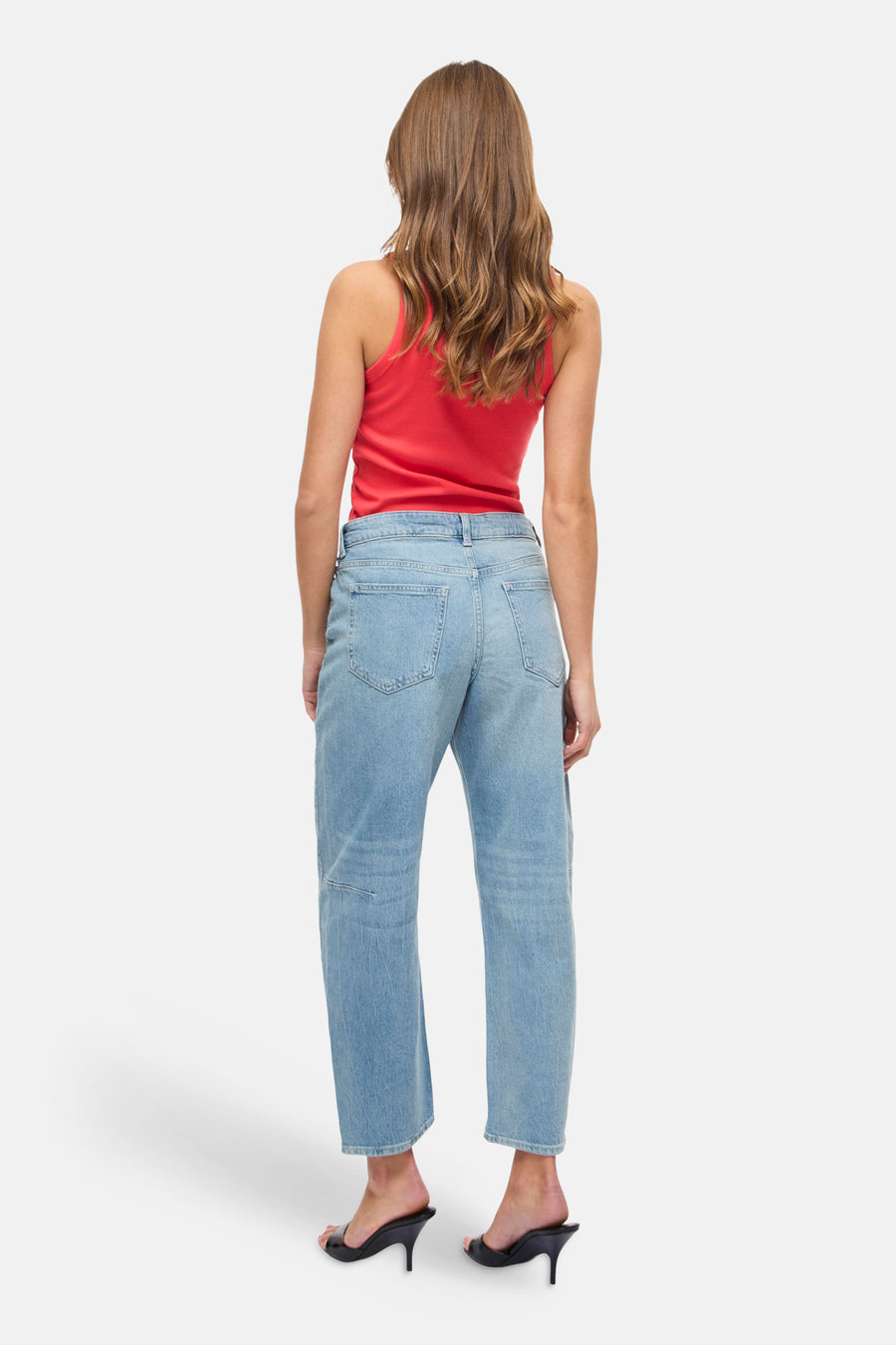 Lichtblauwe spijkerbroek van VILA, gedragen met een rode tanktop en zwarte naaldhakken, achterzicht.