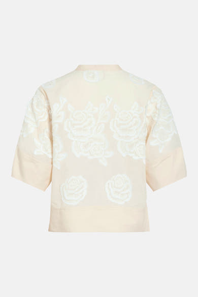 Beige blouse met korte mouwen van ROUGE EDIT met witte bloemenborduursels, achterzijde.