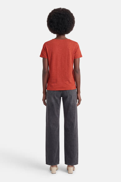 T-shirt orange à manches courtes de VILA, uni et texturé, vu de dos avec un jean gris ample et des mules à talons carrés beiges.