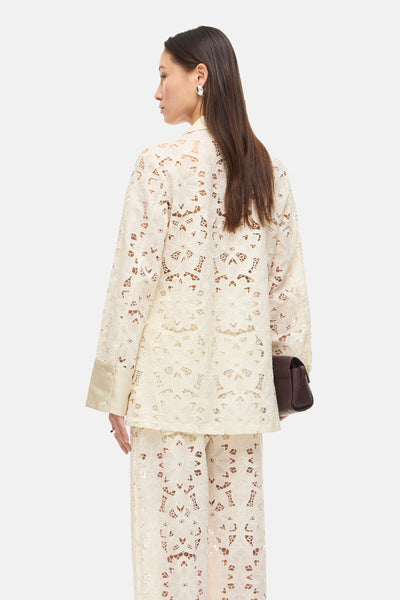 Blazer beige en dentelle par ROUGE EDIT, avec motif floral ajouré et poignets satinés.
