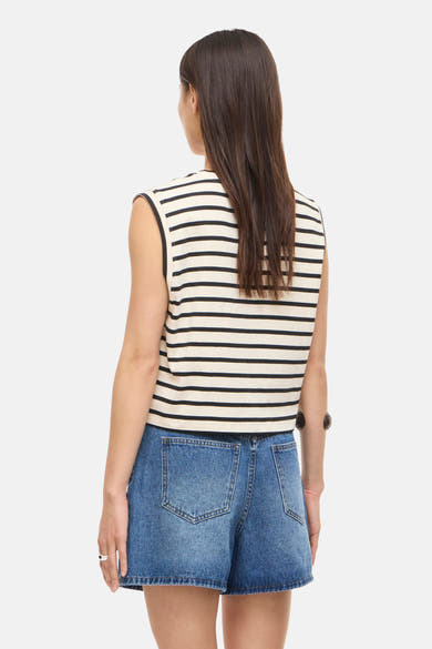 Top sans manches rayé crème et noir de ROUGE EDIT, porté de dos avec un short en jean bleu.