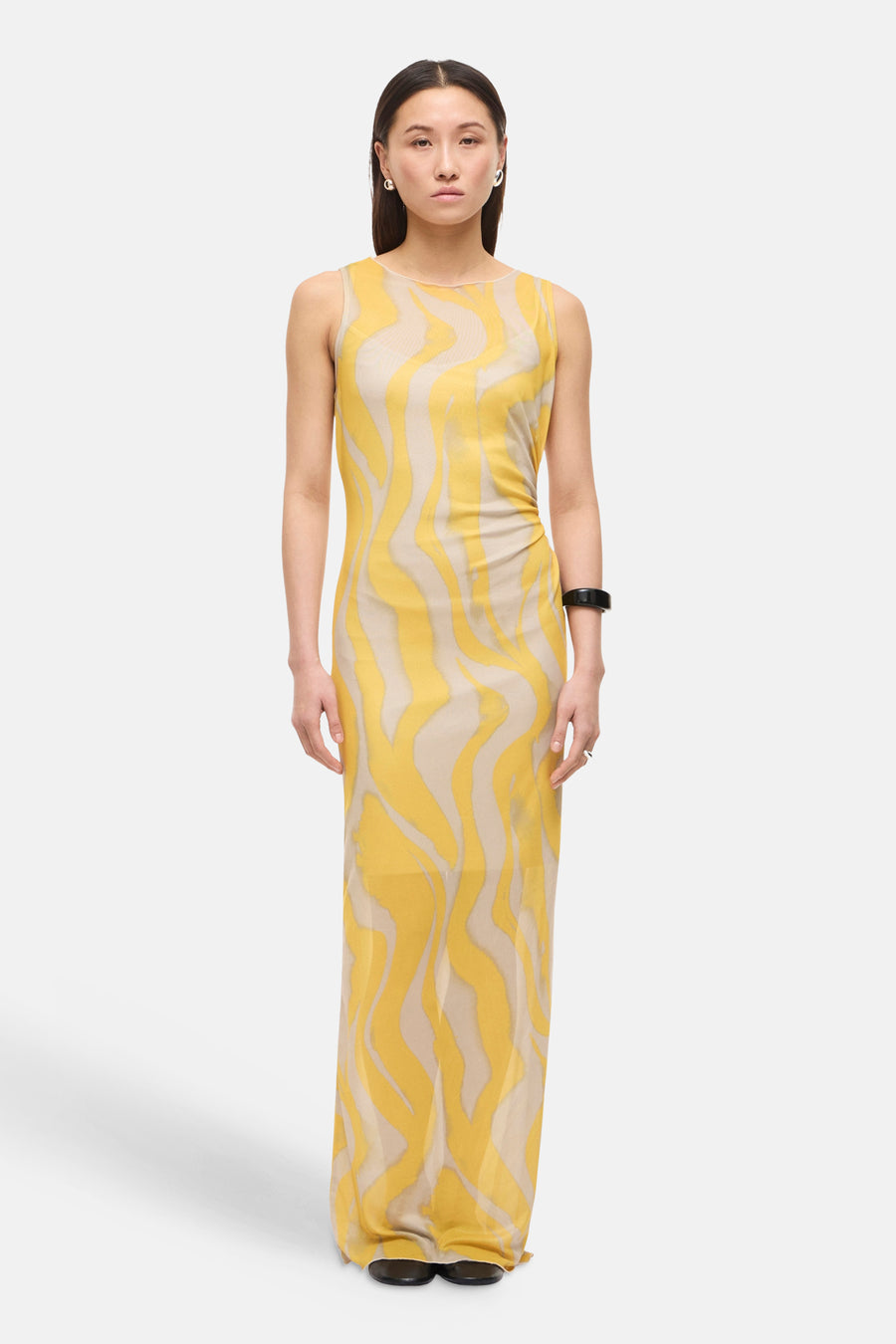 Robe multicolore de ROUGE EDIT, avec motif ondulé jaune et beige, accessoire noir au poignet et bague argentée.
