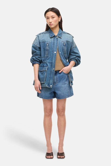 Short en jean bleu moyen de ROUGE EDIT, coupe décontractée, porté avec une veste assortie et des mules marron texturées.