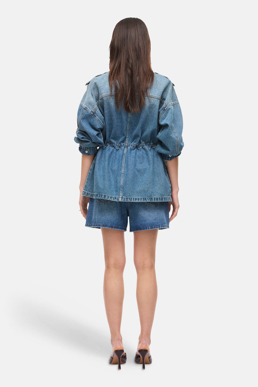 Short en jean bleu moyen de ROUGE EDIT, porté avec une veste en denim et des talons, vue de dos.