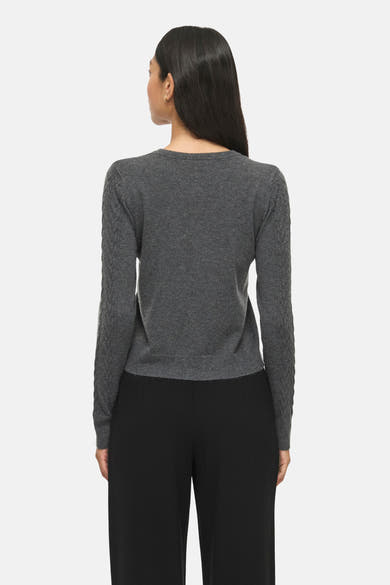 Dark grey melange gilet with cable-knit sleeves and ribbed hem, back view on model wearing black trousers