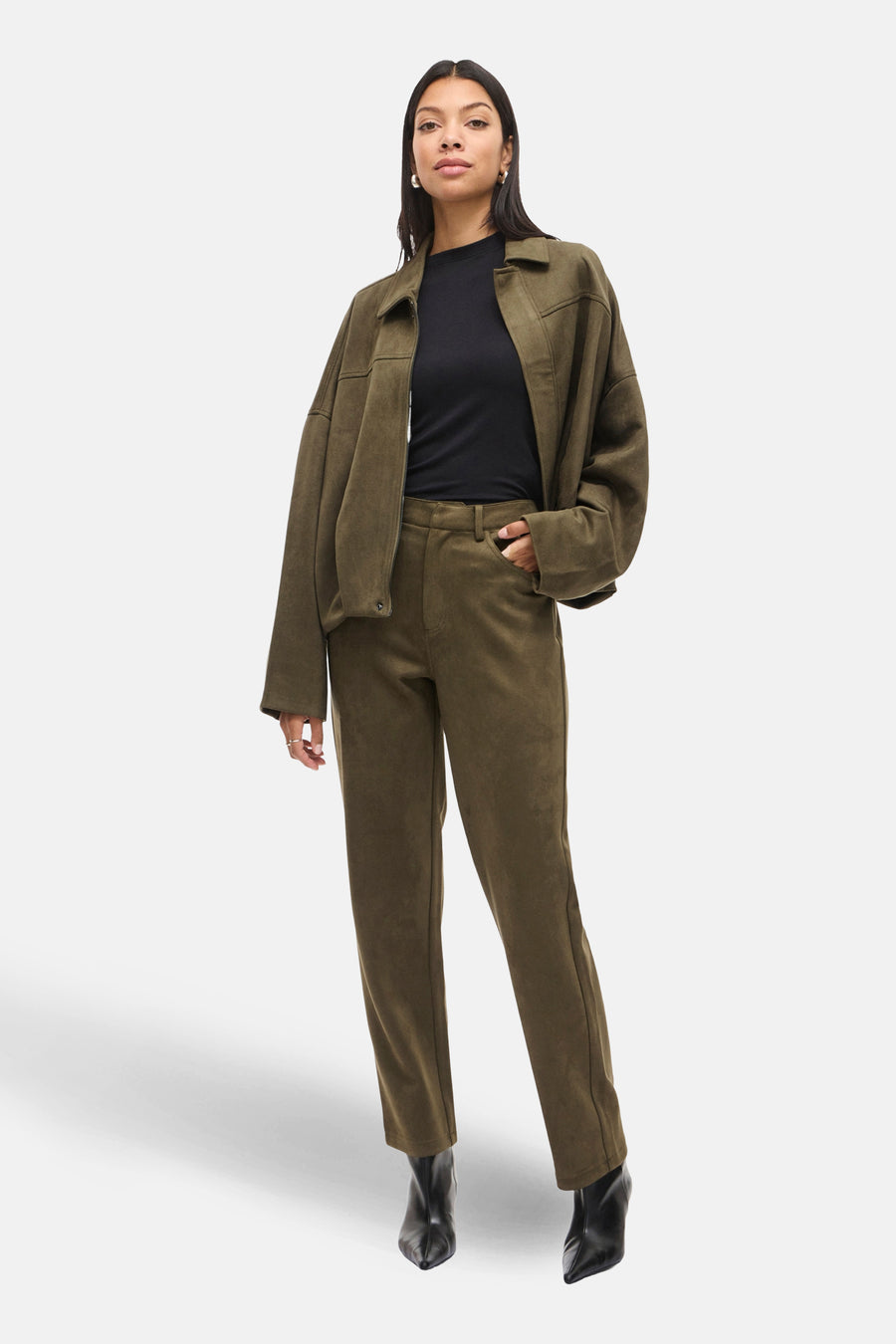 Kort olijfgroen jasje van VILA®, gedragen met een bijpassende broek en zwarte enkellaarsjes.