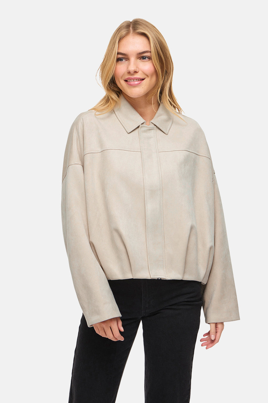 Veste courte beige en suède de VILA®, portée avec un jean noir.