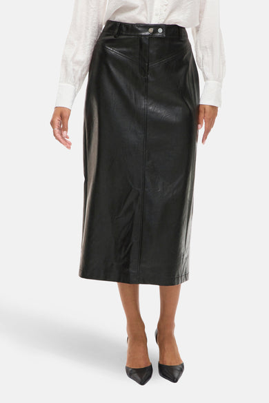 Jupe longue noire en similicuir par VILA®, avec une fente arrière, portée avec une chemise blanche.
