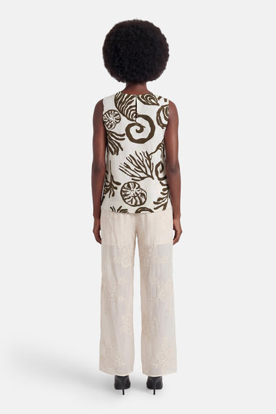 Blouse sans manches écru à motifs marins bruns de VILA®, vue de dos, portée avec un pantalon brodé.