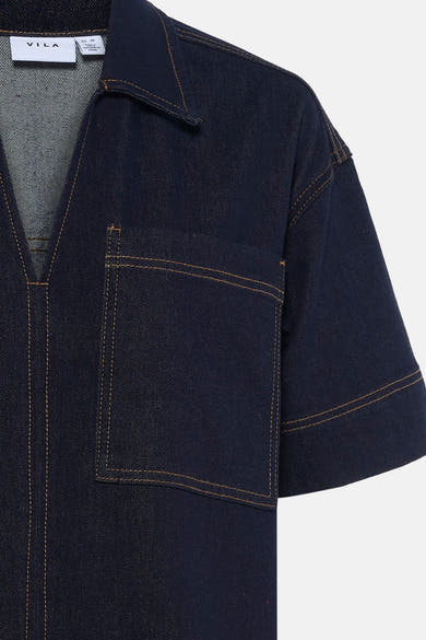 Robe en denim bleu foncé de VILA, avec poche poitrine et coutures contrastantes.
