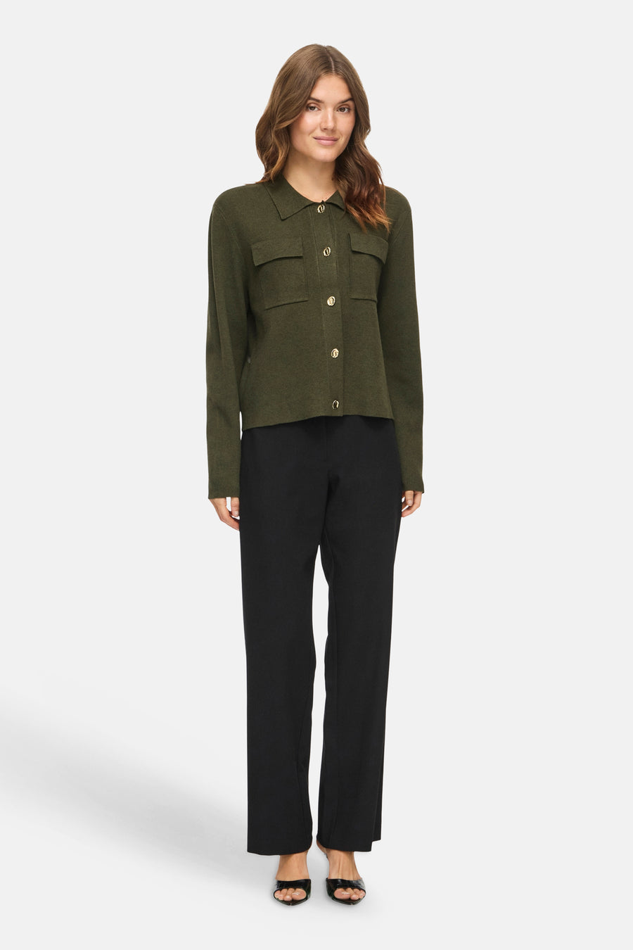 Olive green button-front cardigan with collar and flap pockets, worn with black trousers and open-toe heels, front view.