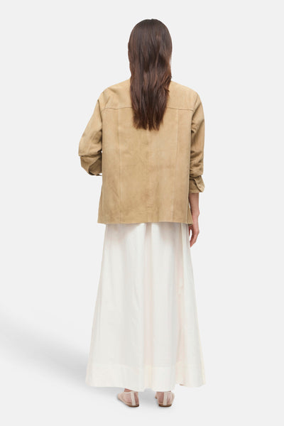 Jupe longue blanche de ROUGE EDIT, portée avec une veste camel et des chaussures plates beiges.