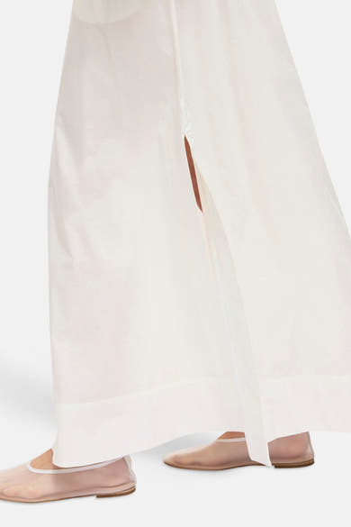 Witte lange rok van ROUGE EDIT, met een subtiele split, gedragen met doorschijnende ballerina's.