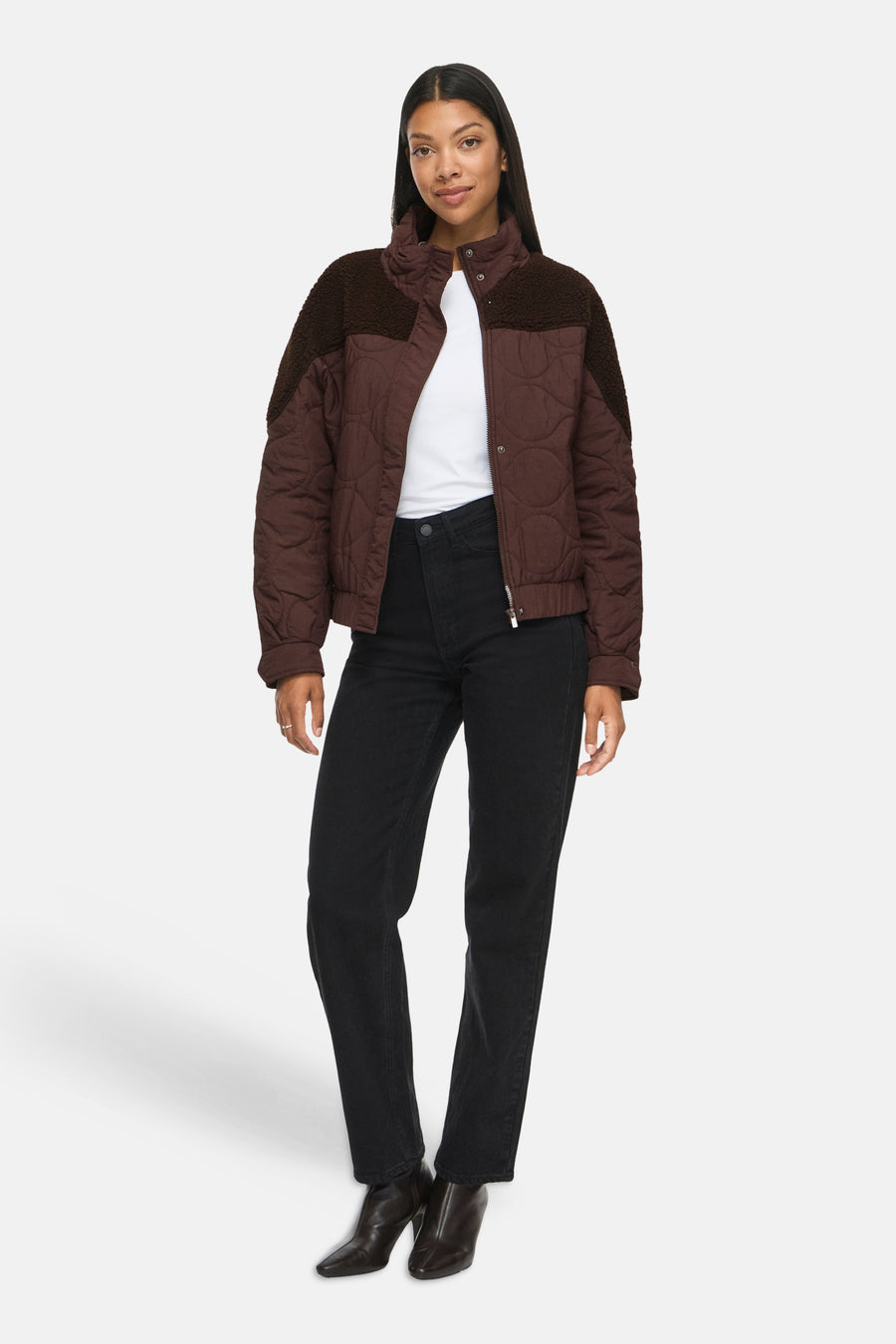 Veste courte marron matelassée par VILA®, col et épaules en fausse fourrure, portée avec t-shirt blanc et jeans noirs, vue de face.