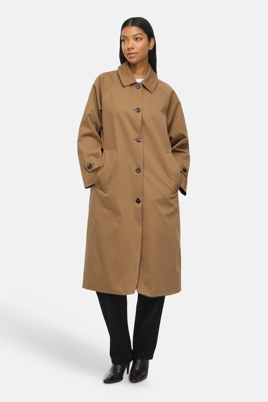 Modèle portant un trench brun VILA® à col rabattu, fermeture boutonnée et poches latérales.