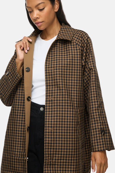 Veste trench à carreaux bruns VILA® portée sur un top blanc
