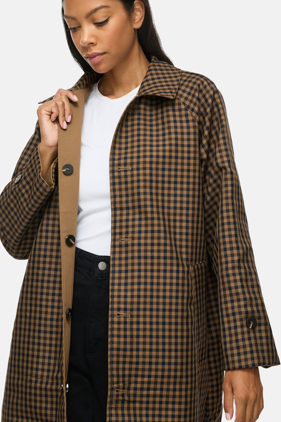 Veste trench à carreaux bruns VILA® portée sur un top blanc