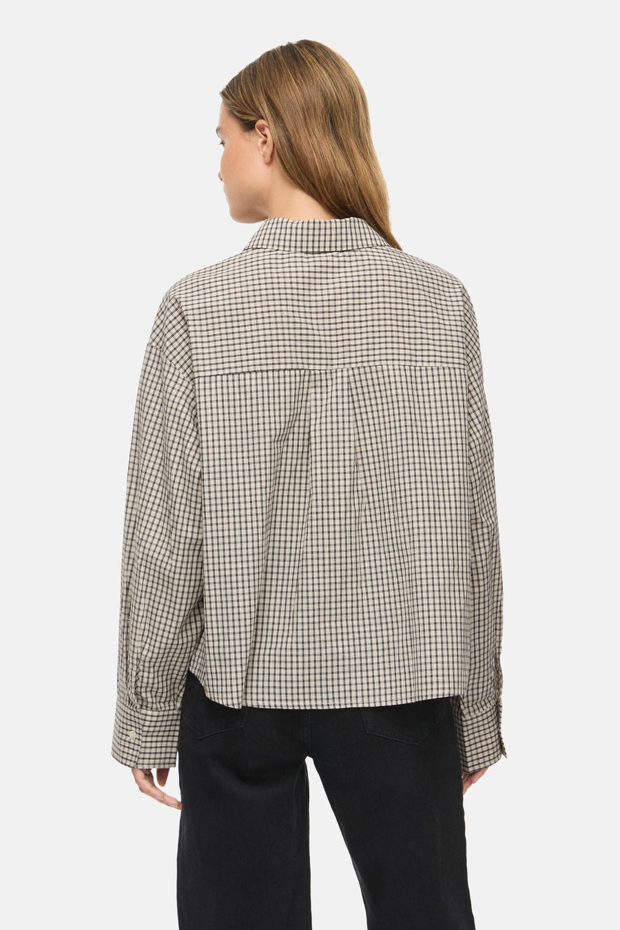 Long-sleeve checkered blouse in beige and black by Birch, back view with relaxed fit and buttoned cuffs, paired with dark pants