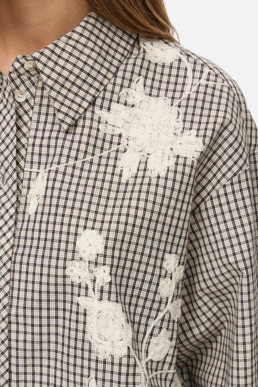 Long-sleeve checkered blouse with white floral lace embroidery, close-up front view