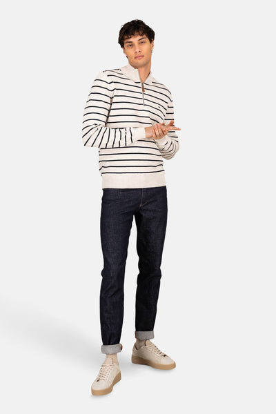 Pull col roulé écru par FYNCH-HATTON avec rayures bleu marine, porté avec un jean et des baskets claires.

