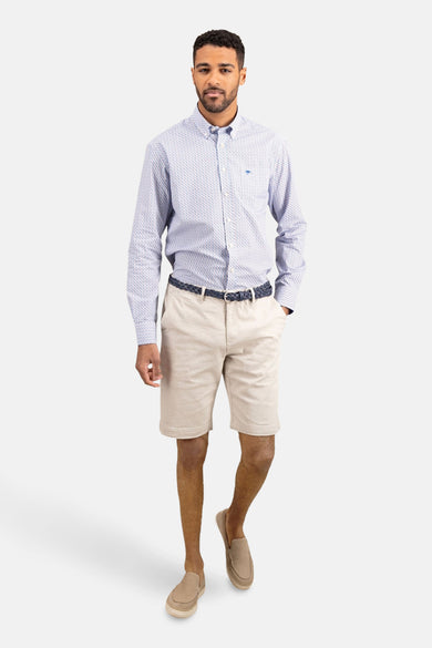 Chemise à manches longues imprimée par FYNCH-HATTON, portée avec un short beige, une ceinture tressée bleue et des chaussures décontractées.